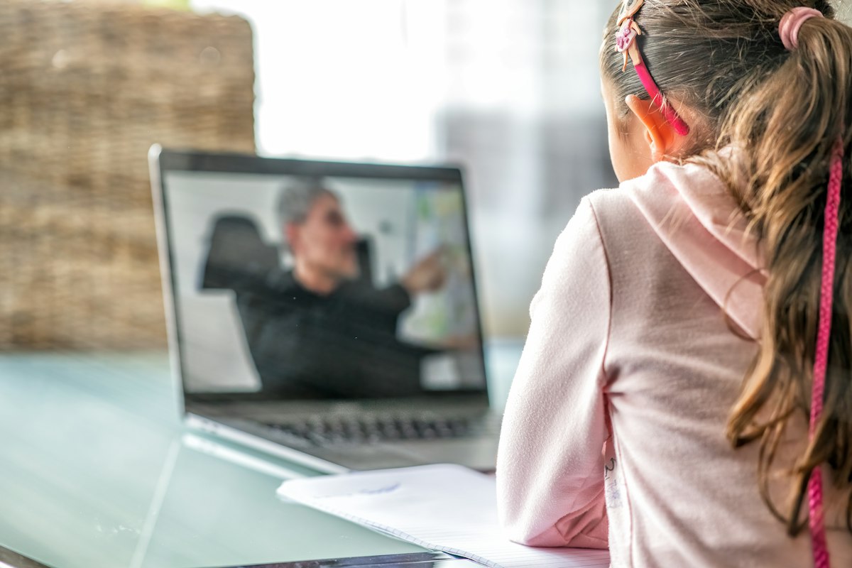 Girl learning from her teacher in a live online class