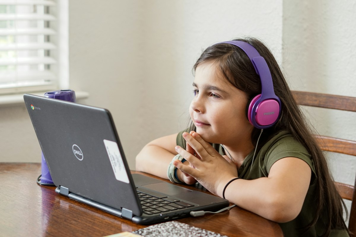 Girl with headphones learning one-to-one with her tutor