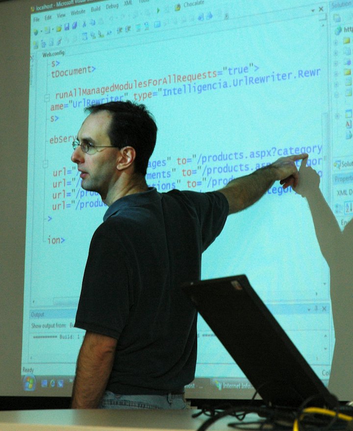 Teacher pointing at a lesson on screen